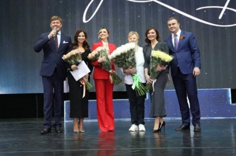 <br />
В костюме стиля сафари и с букетом цветов: зачем Алина Кабаева уехала в Омск                